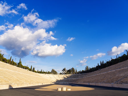Wide angle view of Panathenaic stadium with marble seating under a bright blue sky with fluffy cloudsの写真素材
