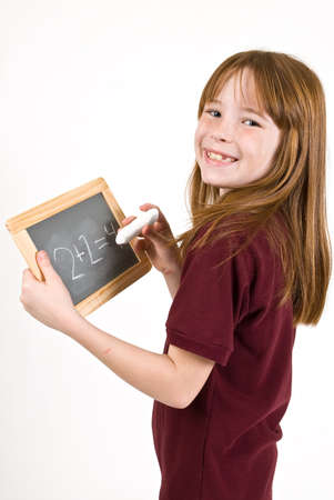 Young school girl writing on chalk boardの写真素材