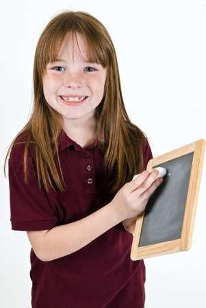 Young school girl writing on chalk boardの写真素材