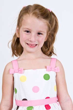 Young Caucasian girl in a polka dot dress facing forwardの写真素材