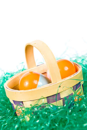 Easter basket wih colorful eggs sitting in artificial grassの写真素材