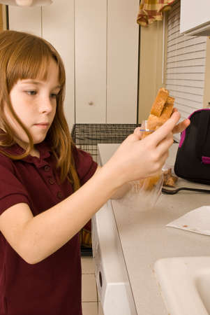 Young school girl preparing her lunchの写真素材