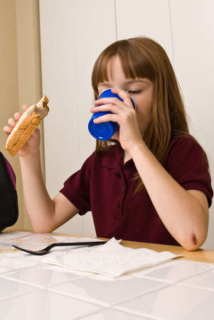 Young school girl eating lunchの写真素材