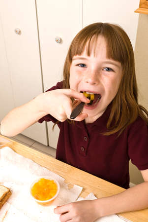 Young school girl eating lunchの写真素材