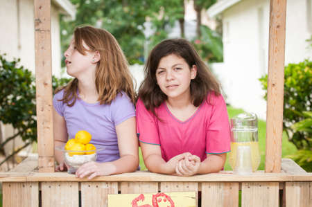 Young girls selling lemonade in a lemonade standの写真素材