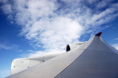Plane wing with white clouds midflight