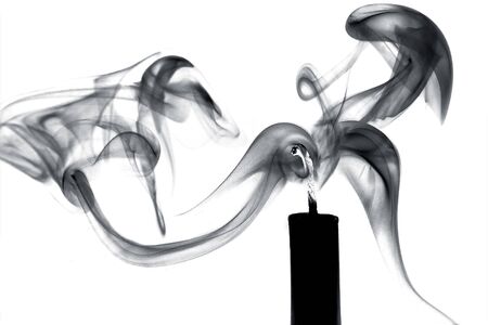 Black candle and smoke on a white backgroundの写真素材