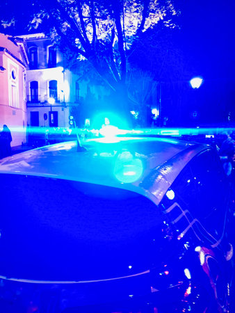 Detail of the Spanish police car. Blue lights with bokeh effect on the roof of a police car with out...