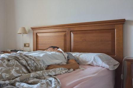 Man sleeping comfortably in his bed at homeの写真素材