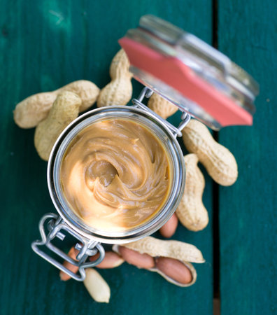 Fresh peanut butter on wooden ground 