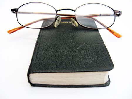 closed book and glasses on a white backgroundの写真素材