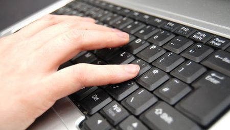 hand typing on a black keyboardの写真素材