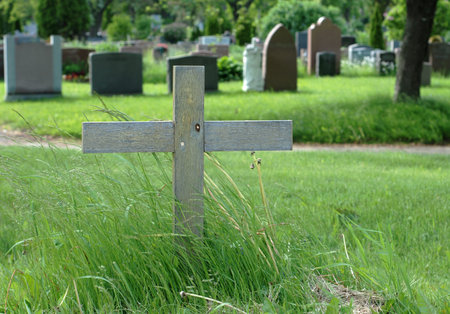 Simple wooden cross in an outdoor cemetery 