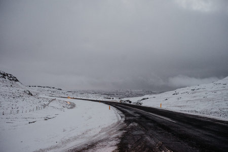 A curvy road leading through a snow covered mountain plateau in Iceland
