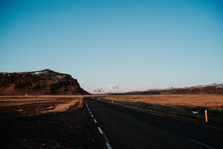 A road leading through a landscape at a mountain Iceland at sunsetの写真素材