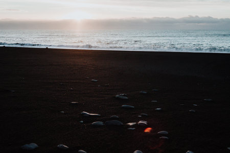 A black sand beach in Iceland with some waves hitting it.
