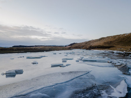 A frozen lake in Iceland with some hills in the background