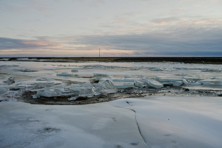 A frozen lake in Iceland in front of a field