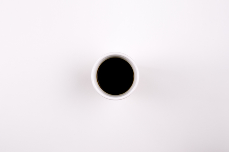 A coffee mug with black coffee in it on light backgroundの写真素材