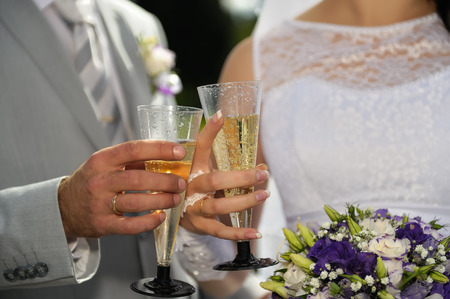 Bride and Groom's champagne toast with focus on the hands and flutes.の写真素材