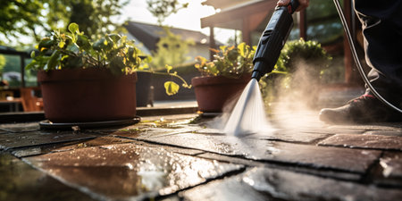 Thoroughly cleanse terrace using powerful water jet to remove grime from paving.の素材