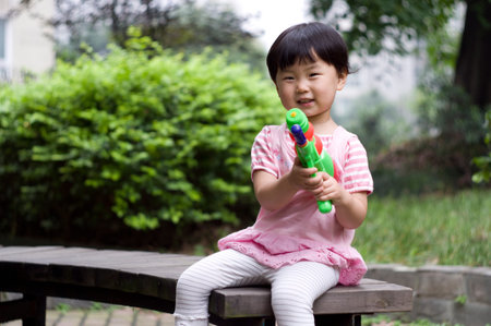 A child is playing with her water pistol.の写真素材