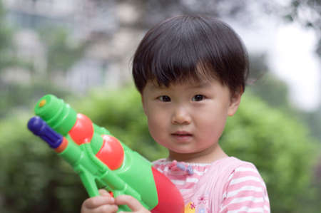 A child is playing with her water pistol.の写真素材