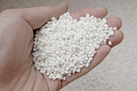Plastic pellets in holding hand, raw material of injection molding.の写真素材