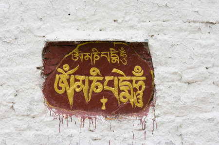 The Sanskrit mantra 'Om mani padme hum' inscribed and painted on a mani stone embedded in a wall of the Potala Palace in Lhasa, Tibet, China.のeditorial素材