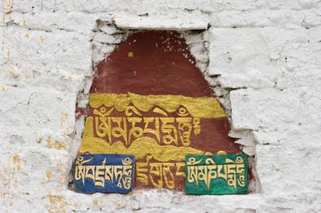 The Sanskrit mantra 'Om mani padme hum' inscribed and painted on a mani stone embedded in a wall of the Potala Palace in Lhasa, Tibet, China.のeditorial素材