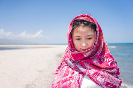 Asian women with red hood at seaside,Shot at Qinghai lake, china.