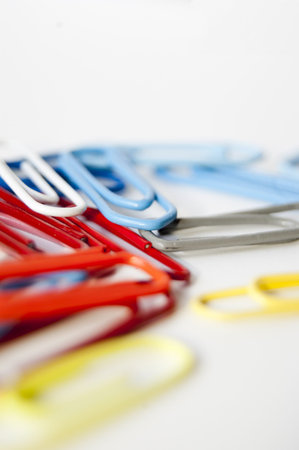 Many colored paper clips isolated on white