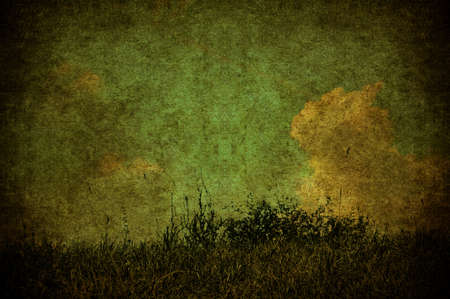 A grunge landscape with meadown and cloudsの写真素材