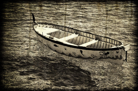 An old colored rowboat anchored in the seaの写真素材