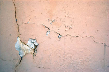 A cracked light pink grunge concrete backgroundの写真素材