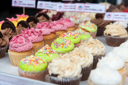 Many sweet birthday cupcakes with flowers and butter creamの写真素材