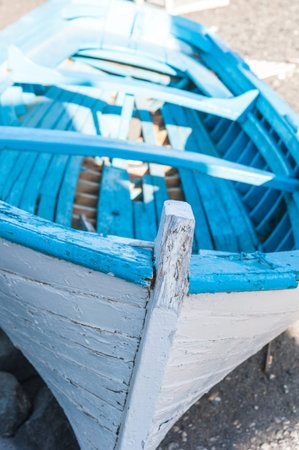 White and blue boat in the beach of Santorini - Greece