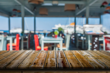 Wooden table in front of a blurred restaurantのeditorial素材