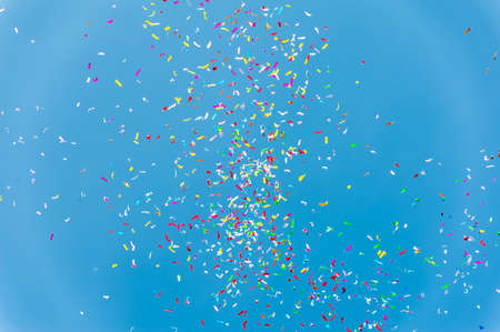 Close up of colorful confetti against a blue skyの写真素材