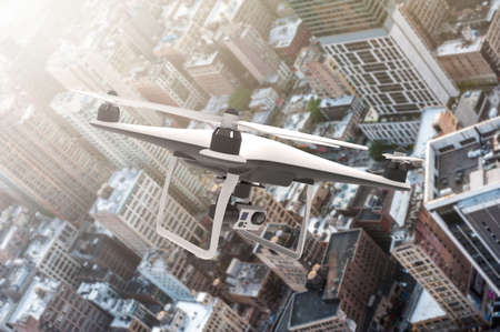 Drone with digital camera flying over a modern city in lightsun: 3D renderingの写真素材
