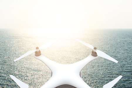 Drone with digital camera flying over sea in sunset: 3D renderingの写真素材