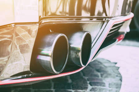 Close up of a car dual exhaust pipe in sunlight backgroundの写真素材