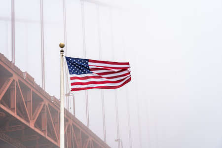 USA flag with Golden Gate Bridge in the fog, San Franciscoの写真素材