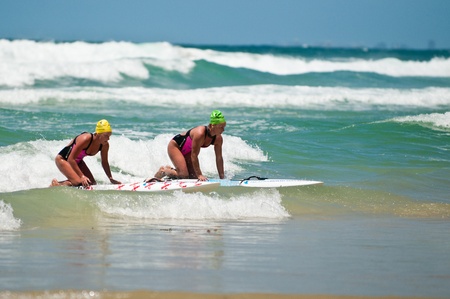 GOLD COAST, SURFERS PARADISE, QLD,  AUSTRALIA - Feb. 2013: Two athlete compete in the boarding stage on the round four of the Surf Ironwoman Series National Championship on February 09th 2013, Gold Coast Australia.のeditorial素材