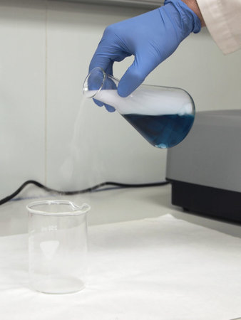 A researcher has a flask with a blue liquid and dry ice, he is pouring it into a beaker....