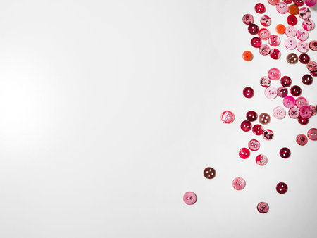 Clothing pink buttons on white background. Sewing and craft concept.