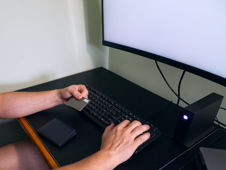 Unrecognizable young man hands buying over the internet with his credit card. Online shopping...