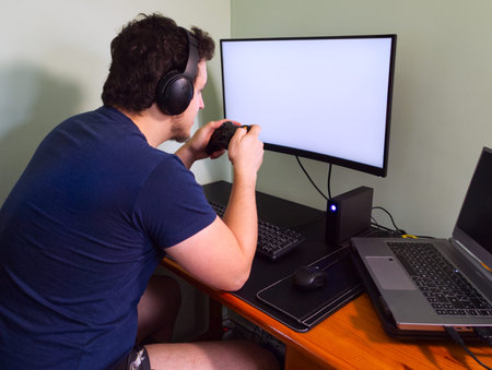 Young caucasian man in his underwear playing video games in a computer with headphones and console...