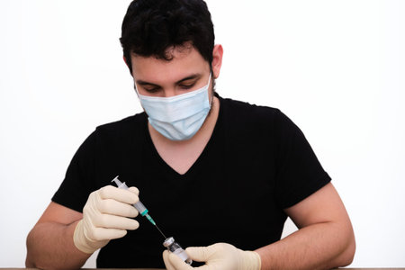 Male nurse getting a shot ready for injection. Coronavirus vaccine concept.