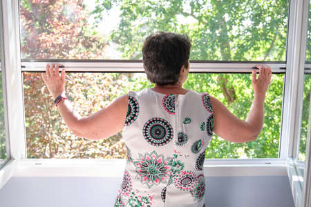 Woman closing the insect screen. Mosquito bite protection concept.の写真素材